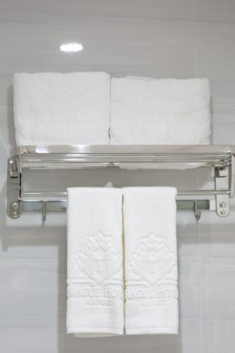 a group of towels on a rack in a bathroom at Prague Saigon Airport Hotel in Ho Chi Minh City