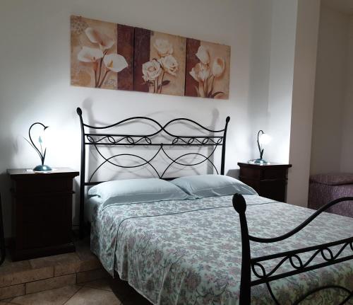 um quarto com uma cama preta e duas mesas de cabeceira em case vacanze, La casa di Angelo, con terrazzo em Oria