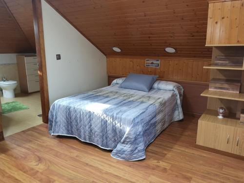 a bedroom with a bed with a blue pillow on it at casa salvante in Moaña