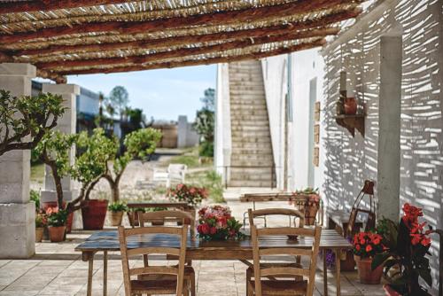 a dining room table with chairs and umbrellas at Masseria Palombara Resort & SPA - Adults only in Manduria