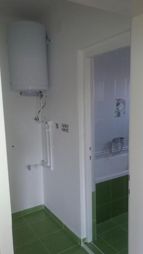 Un baño con ducha con azulejos verdes. en Apartman Lela, en Vranje