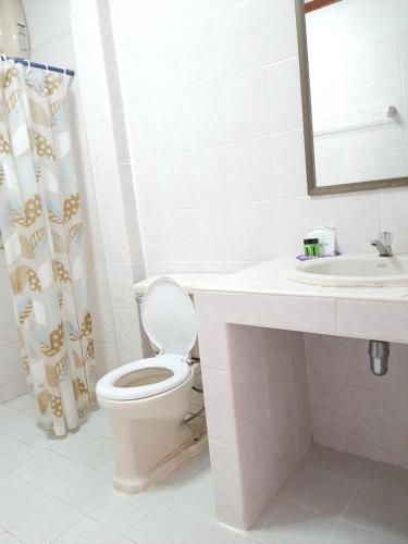 a white bathroom with a toilet and a sink at สตาร์ รีสอร์ท (สี่แยก จปร) in Nakhon Nayok