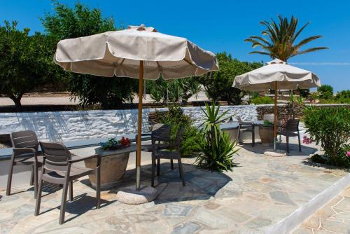 a patio with tables and chairs and an umbrella at Arhontou in Apollonia