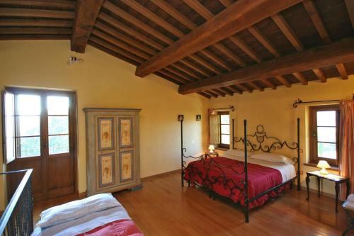 a bedroom with a bed in a room with wooden floors at Podere Caldaruccio La Pineta in Bosco