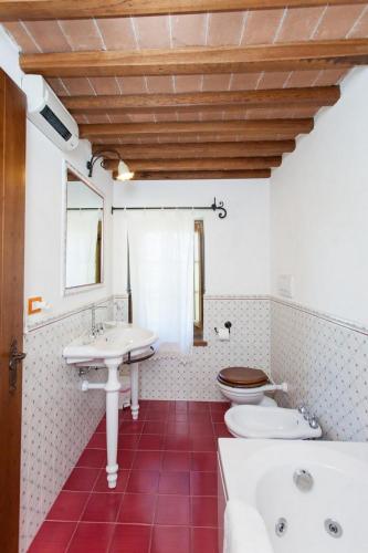a bathroom with a white sink and a toilet at Podere Caldaruccio La Pineta in Bosco