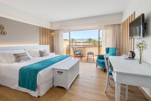 
a hotel room with two beds and a television at Barceló Corralejo Bay - Adults Only in Corralejo
