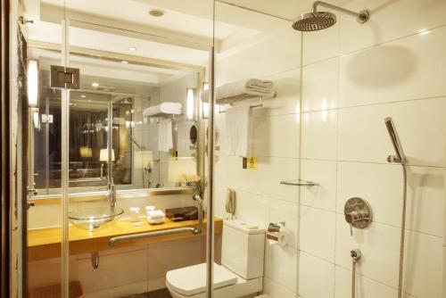a bathroom with a shower and a toilet and a sink at Leeden Hotel Guangzhou in Guangzhou