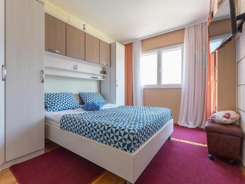 a small bedroom with a bed and a window at Romantic apartments Marko for 2 with pool and grill in Zaton