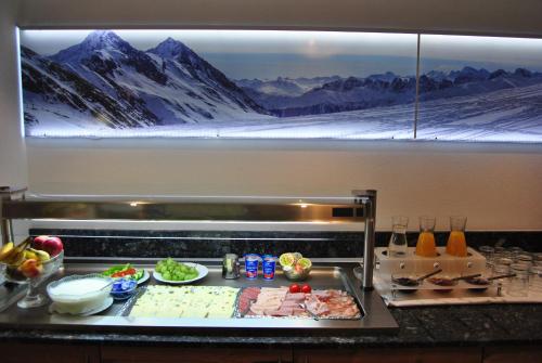 a kitchen with food on a counter with mountains at Gästehaus Hochstaffl in Gerlos
