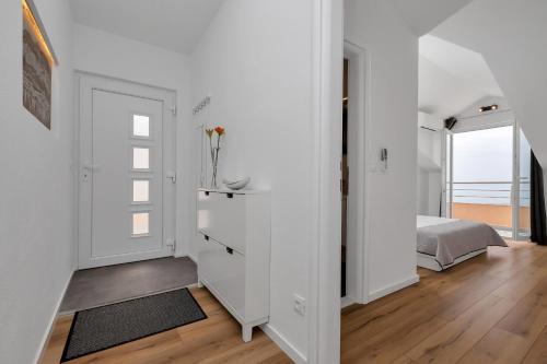 a white bedroom with a bed and a window at Villa Sukara in Makarska