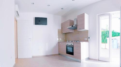 a white kitchen with a stove and a window at Golden Residence in Caianello