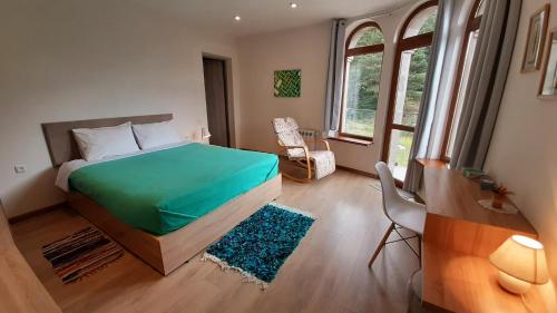 1 dormitorio con 1 cama con edredón verde en LerMont Guest House, en Lermontovo
