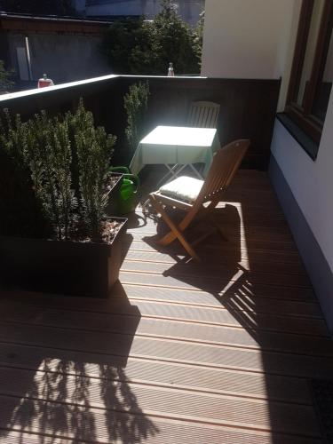 a patio with a table and a chair and plants at Comfort Rooms Bruckner in Bad Gastein