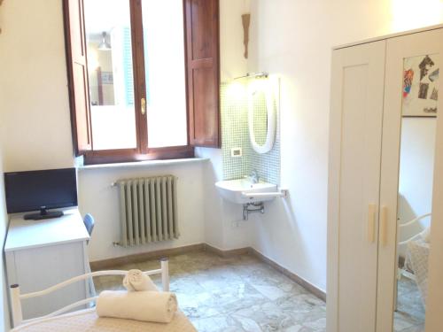 a small bathroom with a sink and a mirror at HostelCiompi in Siena