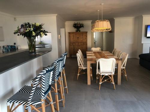 a dining room with a wooden table and chairs at The Sanctuary Penthouse in Plettenberg Bay