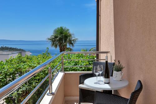 a table and chairs on a balcony with a view of the ocean at Villa Sukara in Makarska