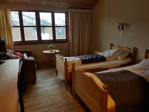 een kamer met 3 bedden en een raam bij Bykle Hotel in Bykle