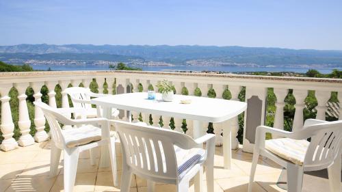 - Balcón con mesa blanca y sillas en Four Bedrooms Villa Anita en Polje