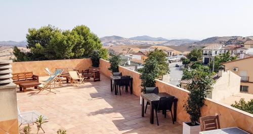 a patio with tables and chairs on a balcony at Apartamentos Villa Torcal in Villanueva de la Concepción