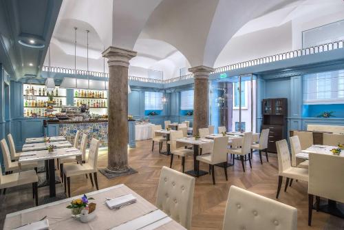 un restaurante con mesas y sillas y un bar en Hotel Martis Palace en Roma