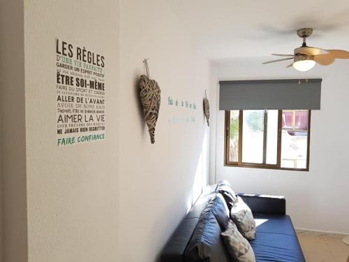 ein Wohnzimmer mit einer Couch und einem Deckenventilator in der Unterkunft Superbe appartement à Costa Antigua in Costa de Antigua