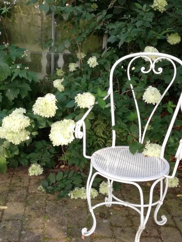 a white chair sitting in front of some flowers at Tankefuld Living's Horsefarm in Svendborg