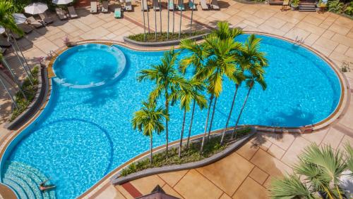 an overhead view of a swimming pool with palm trees at THE PRIVILEGE FLOOR by Borei Angkor in Siem Reap