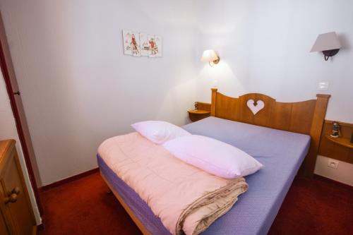 a bedroom with a bed with two pillows on it at Residence Les Terrasses d'Azur - maeva Home in Isola 2000