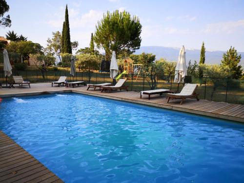 a swimming pool with lounge chairs and umbrellas at La Bastide du Limon in Mormoiron