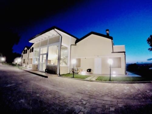 a large white building with glass windows at night at Agriturismo Tenuta Villa Catena in Paglieta