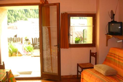 a room with a bedroom with a door and a window at Le Serre Grou studioLarge studio at the gateway to the Ecrins National Park in Villar-dʼArène