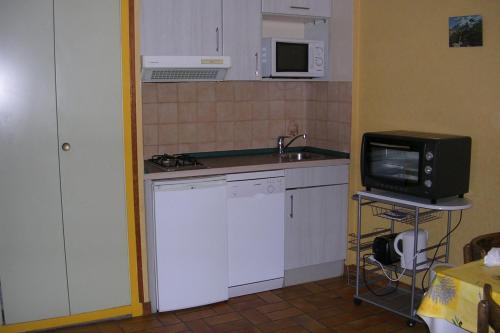 a small kitchen with a sink and a microwave at Le Serre Grau 2 pcs - Apartment facing South and the forest in Villar-dʼArène