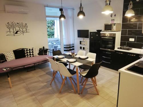 Rab centar في راب: مطبخ وغرفة معيشة مع طاولة وكراسي