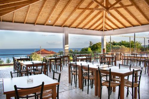 コロニにあるZagaMilos Hotelの海とテーブルと椅子が備わるレストラン