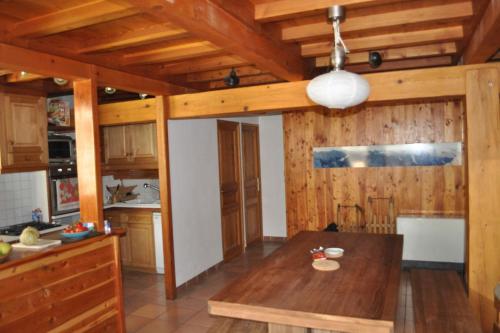 a kitchen with wooden walls and a wooden table at Boréales - spacious duplex - in La Grave-La Meije heart in La Grave