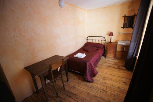 a small bedroom with a bed and a table at Chez Jean Pierre - Room 1pers in a 17th century house - n 6 in Villar-dʼArène