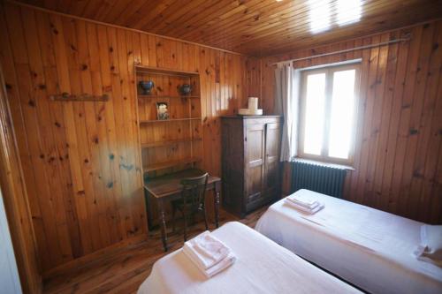 1 dormitorio con 2 camas, ventana y escritorio en Chez Jean Pierre - Bedroom in a 17th century house - n 4, en Villar-dʼArène