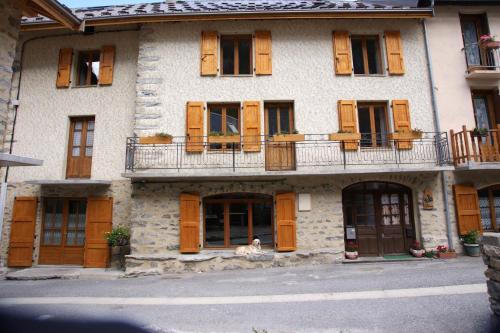 un vecchio edificio con porte e finestre in legno di Chez Jean Pierre - Room 1pers in a 17th century house - n 6 a Villar-dʼArène