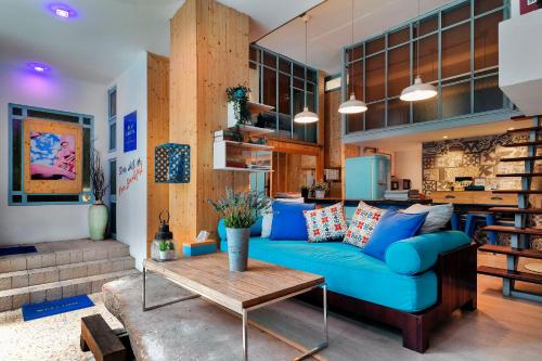a living room with a blue couch and a table at Blu Cabin Gay Poshtel in Bangkok