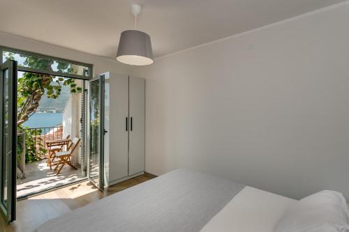 a bedroom with a bed and a view of the ocean at Boka Apartment 4 in Herceg-Novi