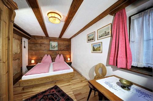a small room with a bed and a table at Ferienhäuser Reither Almen in Reith im Alpbachtal