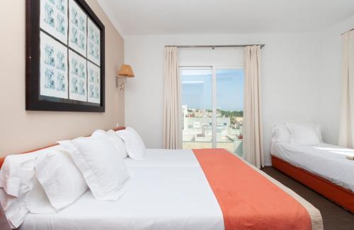 a hotel room with two beds and a window at Portofino Mallorca in Palma de Mallorca