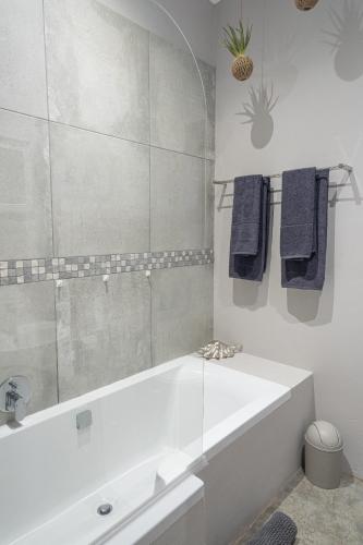 a white bathroom with a tub and a mirror at Steenbok Farm Cottages Steenbok cottage in Wolseley
