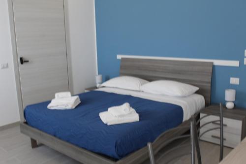 a bedroom with a bed with towels on it at Naxos Laguna Beach in Giardini Naxos