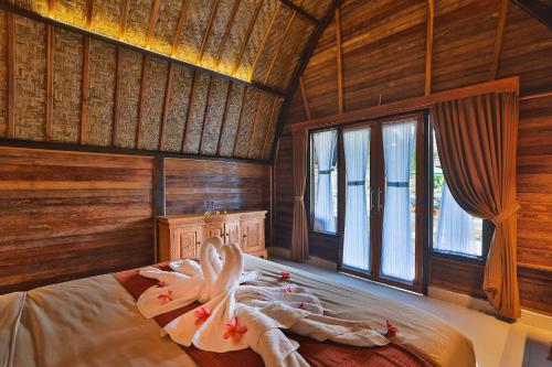 Mamaras Guest House في نوسا بينيدا: غرفة نوم بسرير في غرفة بجدران خشبية