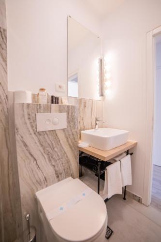 a bathroom with a white toilet and a sink at Villa Astra in Brela