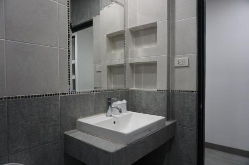 a bathroom with a sink and a mirror at Heaven Apartments in Patong Beach