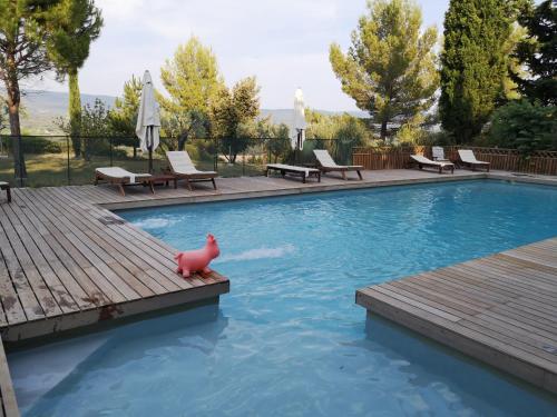 una piscina con un pato de goma rosa en una terraza de madera en La Bastide du Limon, en Mormoiron