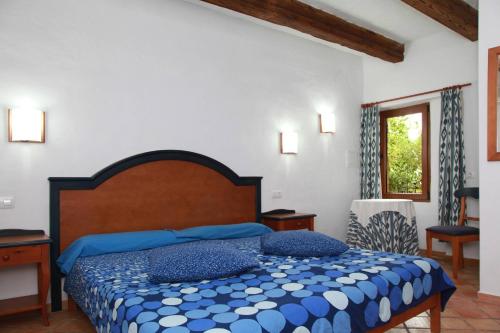 Un dormitorio con una cama grande con almohadas azules. en Finca Son Guardiola, en Llucmajor
