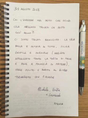 a notebook with a pen and aritten document at La Casa del Sole in Marina di Pisticci